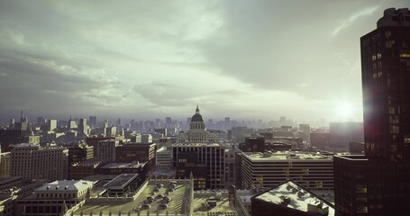 golden sunrise over capitol dome and rooftops, warm light highlighting historic masonry and classical facades, quiet civic plaza framed by urban panorama, © icetray