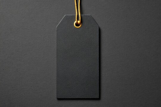 Black tag with gold string on dark background blank label