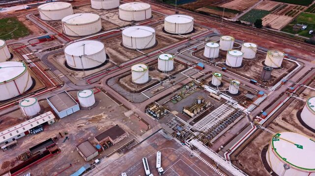 Flight over the industrial area with small and large tanks for oil storage. Resources and business concept.