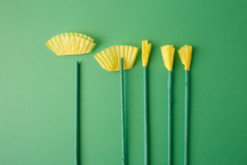 Eco friendly paper flower stems preparation on green background. Useful for sustainable craft business, florist shop marketing, zero waste lifestyle blog, creative agency mockup, handmade product art.