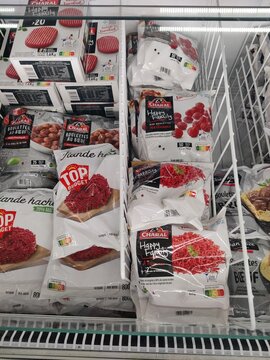 Saujon, France - January 24, 2026: Intermarche. Frozen food display featuring various packaged meat products and frozen raspberries in a supermarket freezer section