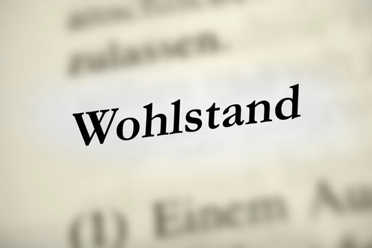 Wohlstand - deutsches Textwort auf gelblichem Hintergrund