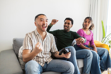 Friends enjoying video game playing and celebrating victory
