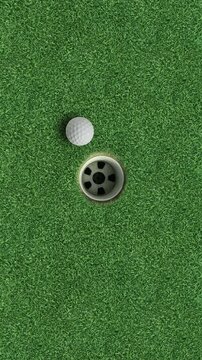 Golf ball in hole on green grass putting surface vertical sports background with large copy space for text golf success concept