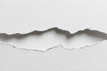 Close-up of ripped white paper, showing jagged edges and shadow