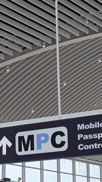 Modern airport terminal sign indicating the direction for Mobile Passport Control - MPC - , a U.S. Customs and Border Protection program for travelers entering the United States