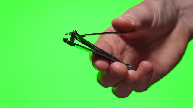 Manicure nippers in hand on isolated background
