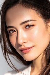 Obraz premium A confident woman smiling in casual fashion, glowing with white natural beauty and radiance in soft indoor lighting with a bright background.