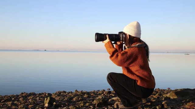 A 36-year-old female solo traveler using a telephoto lens to capture the sunrise at Ebro Delta, Tarragona, Spain.