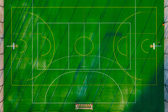 Aerial view of a vibrant green sports field marked with crisp white lines, creating geometric patterns against the lush backdrop, Warsaw, Masovian Voivodeship, Poland.