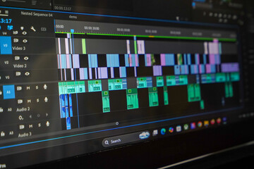 Fototapeta premium Professional video editing software interface showing complex timeline with video tracks and audio waveforms on computer screen.