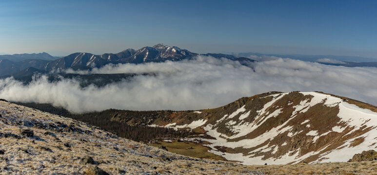 This scenic Colorado mountain panorama features Sawatch Range 13er Antora Peak rising above a late spring cloud inversion.