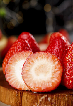 Fresh Dandong Strawberries Cut in Half Showing Rich White Flesh Interior on Wooden Cutting Board