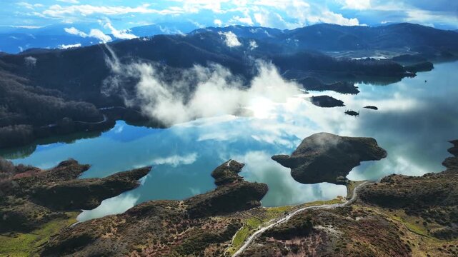 Aerial drone cinematic video of amazing artificial lake Aoou with beautiful nature and reflecting clouds near picturesque village of Metsovo surrounded by mountains of Pindus, Epirus, Greece