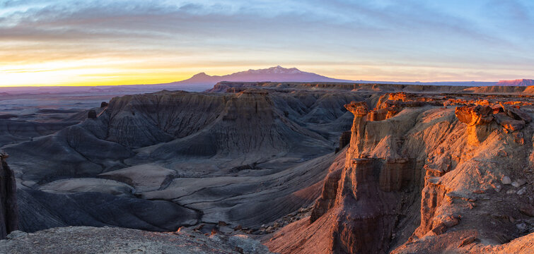 This stunning sunrise panorama of the southern San Rafael Swell features the rugged moonscape badlands with the Henry Mountains in the distance.