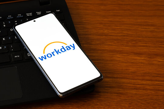 Punta Arenas, Chile &ndash; March 05, 2026: A smartphone screen displaying the Workday logo, resting on a black laptop keyboard over a polished wooden desk