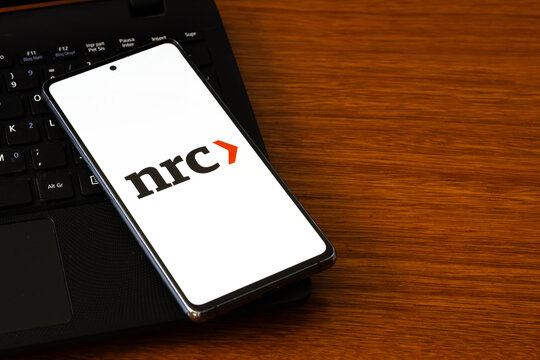 Punta Arenas, Chile &ndash; March 05, 2026: A smartphone screen displaying the NRC (NRC Handelsblad) logo with its signature orange arrow, resting on a black laptop keyboard