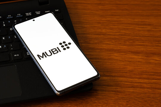 Punta Arenas, Chile &ndash; March 05, 2026: A smartphone screen displaying the MUBI streaming service logo with its distinctive dot pattern icon, resting on a black laptop keyboard