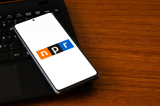 Punta Arenas, Chile &ndash; March 05, 2026: A smartphone screen displaying the National Public Radio (NPR) logo in its signature orange, black, and blue blocks, resting on a laptop keyboard