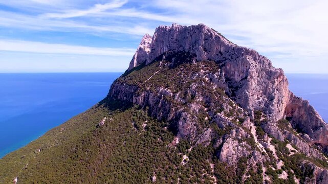 Italy Sardinia Tavolara island mountain peak 4K drone. Aerial limestone ridge. Cinematic flight along rocky summit with crosses. San Teodoro landmark nature