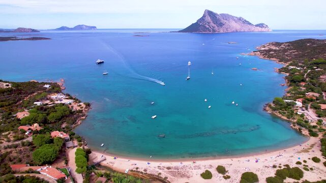 Italy Sardinia  beach 4K drone. Porto san Paolo and Tavolara mountain view. Local sea shore and boats. Mediterranean island travel. San Teodoro coast