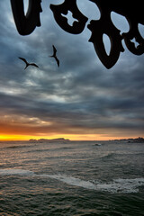 Fototapeta premium La Rosa Náutica glows above the Pacific at sunset in Miraflores, Lima, as surfers and evening visitors embrace an active coastal lifestyle, reflecting safe travel experiences and the growing appeal of