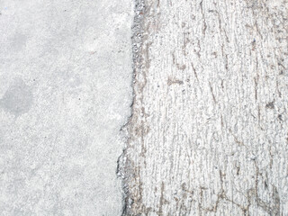 Close up of an old cement pavement features various shades of gray with white spots and grainy...