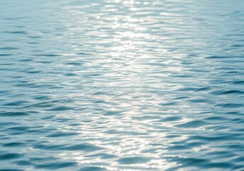 Ripples on the surface of clear blue water reflecting sunlight