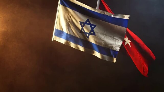 flags of israel and turkey in dramatic light on dark smoky background close up