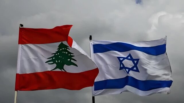 flags of lebanon and israel wave side by side against a cloudy grey sky reflecting the current state of bilateral relations and uncertainty of the future in the border zone