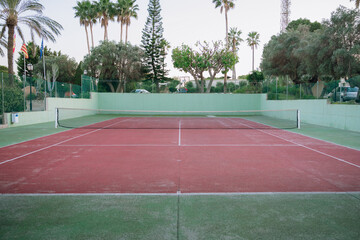 Naklejka premium Outdoor tennis court with red surface and net