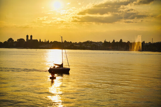 Segelboot kehrt im Sonnenuntergang zur&uuml;ck in die Marina von Lindau, Bayern, Deutschland