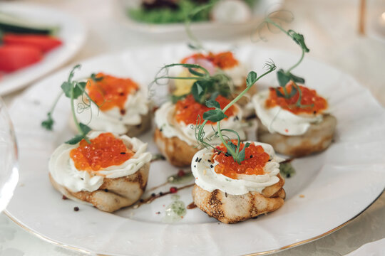 Dishes on the festive table. Sandwiches with red caviar and butter