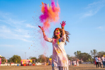 Fototapeta premium Young Woman Celebrating Holi Festival of Colors Outdoors Throwing Bright Powder and Smiling