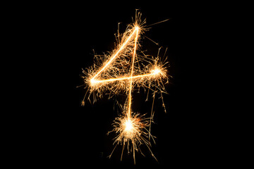 Fototapeta premium Sparkler Cross with Golden Light Trail on Black Background