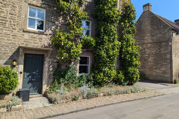 Exterior view and garden of a beautiful old rural house on a street in an English village