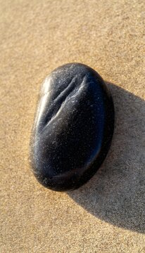 Smooth river stone reflects gentle sunlight on Swamis Beach a serene coastal nature photograph
