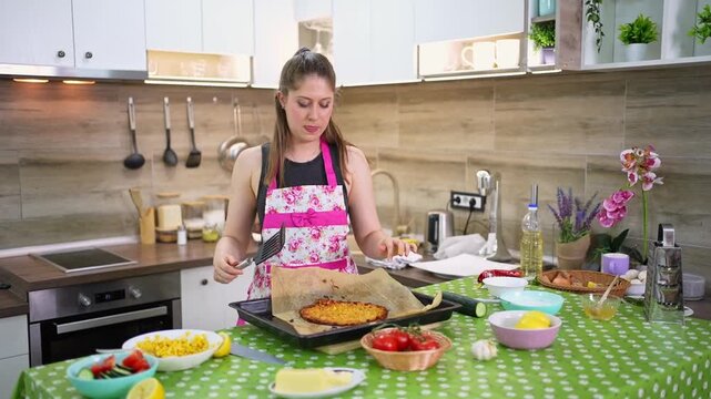 Young woman comically struggling to cook a homemade dish