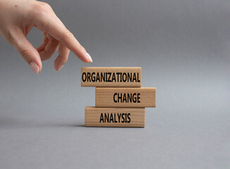 Naklejka na ściany i meble Organizational Change Analysis symbol. Concept word Organizational Change Analysis on wooden blocks. Businessman hand. Beautiful grey background. Business Analysis . Copy space