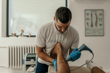 Therapist applying shockwave therapy to client's leg