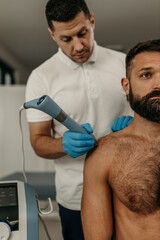Therapist administering radial shockwave therapy to shoulder injury