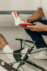 Professional explaining foot anatomy using model during rehabilitation