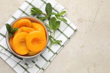Pickled peaches and mint leaves in bowl on light grey table, flat lay. Space for text © New Africa