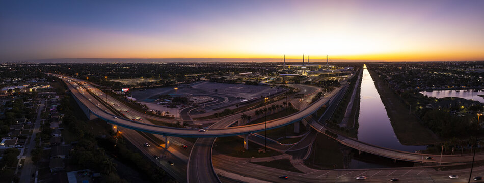 Aerial view of the Hard Rock Stadium and Florida Turnpike interchange glowing under the fading light, Miami Gardens, Florida, United States.
