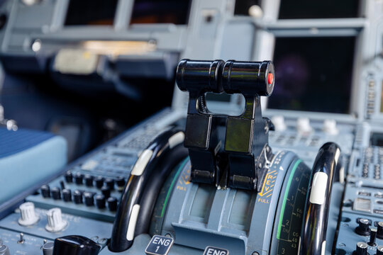 Close-up view of engine throttle levers inside commercial airplane cockpit. Aviation control, flight operation, pilot workspace, technology, and transportation concept.