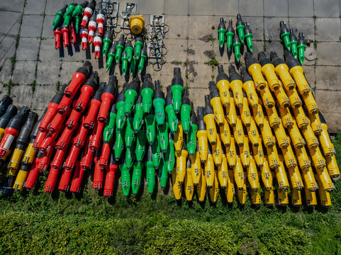 Aerial view of colorful equipment, neatly arranged in rows, contrasting against the gray concrete and green grass, Aquaduct Veluwemeer, Harderwijk, Gelderland, Netherlands.