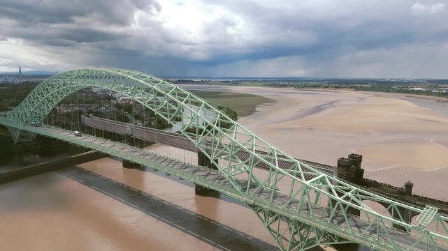 Liverpool, Merseyside, UK, September 09, 2025; aerial 4K video footage of the Silver Jubilee Bridge and Britannia Railway Viaduct over the River Mersey and Manchester Ship Canal, Runcorn, Merseyside