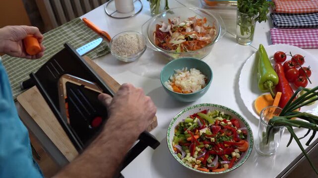 Over the Shoulder View of Man Slicing Vegetables with Mandoline Slicer. High-quality vegetarian cooking and healthy lifestyle concept.
Search VITAL-CHEF54 for more from this collection.