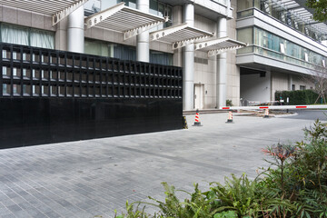 Naklejka premium Modern building entrance with black grid fence and architectural details in urban setting