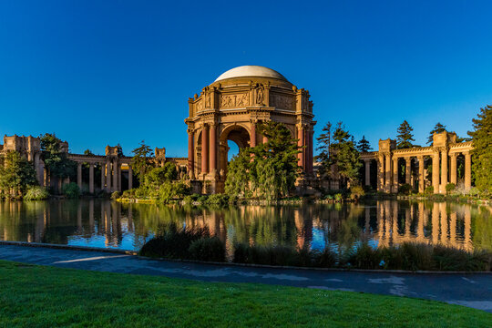 Palace of Fine Arts building stands by water in a park during daylight with clear sky and greenery